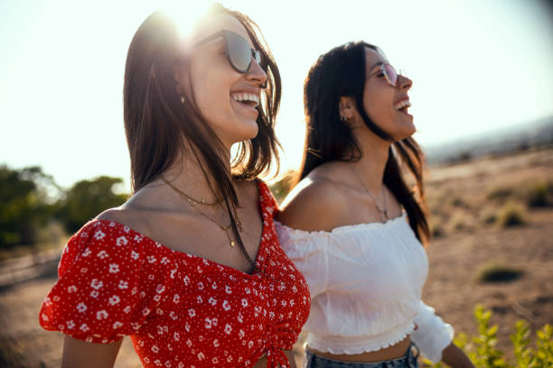 istock Two smiling young women talking anad laughing while enjoying summer on road trip. 1330106096