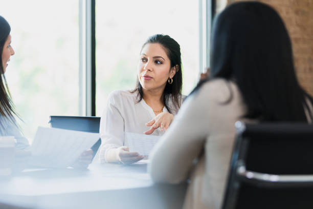 istock Three businesswomen meet to discuss paperwork 1330107314