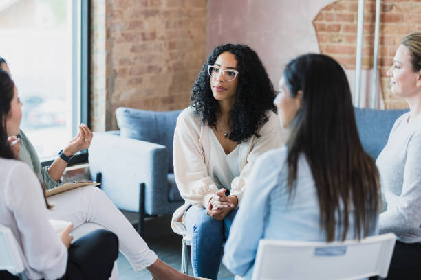 istock Unseen woman gestures and therapy group members listen 1330107335