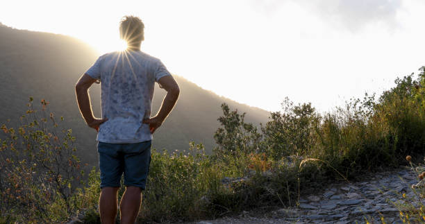 istock Man hikes through mediterranean hillside at sunrise 1330107384