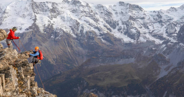 istock Mountaineering couple climb up to mountain peak 1330107433