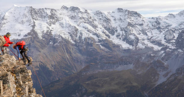 istock Mountaineering couple climb up to mountain peak 1330107435