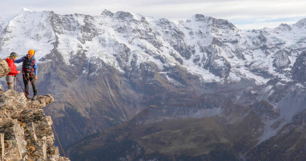 istock Mountaineering couple climb up to mountain peak 1330107439