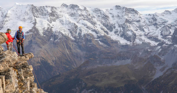istock Mountaineering couple climb up to mountain peak 1330107450