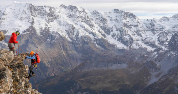 istock Mountaineering couple climb up to mountain peak 1330107459