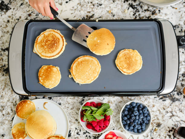 istock Woman Cooking Pancake Breakfast in a Home Kitchen 1330109081