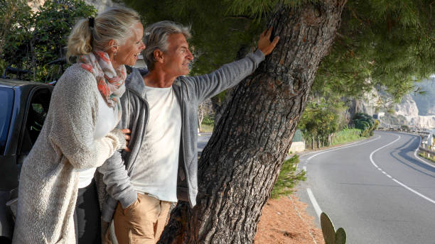 istock Mature couple relax under tree near coastal road 1330113492