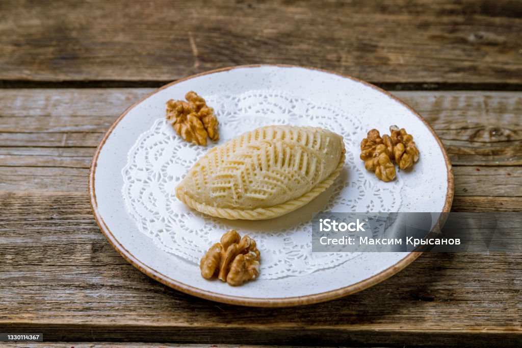 sekerbura with walnuts on white plate on old wooden table Baku Stock Photo