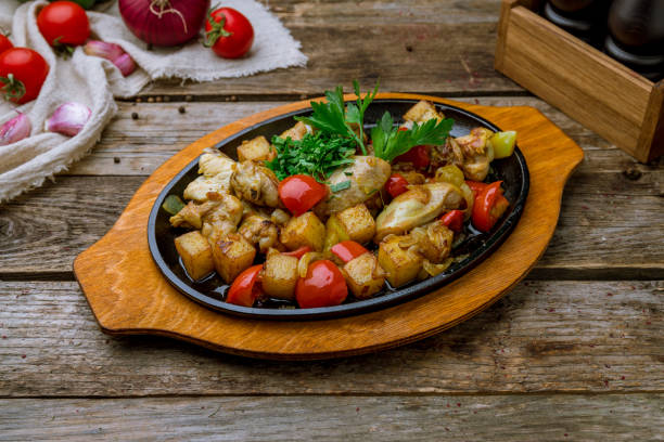 frango pan-frito com batatas em mesa de madeira velha - animal skin prepared potato chicken leg chicken - fotografias e filmes do acervo