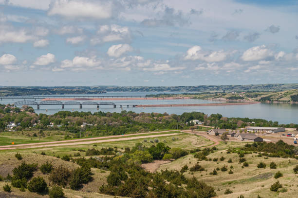 The 3 river crossings over Missouri in Chamberlain, SD, USA. Chamberlain, SD, USA - June 2, 2008: The 3 Missouri River crossings under blue cloudscape. Farm with green land and lots of trees. bridge crossing cloud built structure stock pictures, royalty-free photos & images