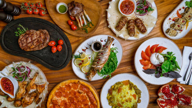 suculento bife ribeye, robalo frito, rack de cordeiro, kebab lula de viário, rolos de auberdine, salada com buratta e tomates, tabaco de frango, pizza pepperoni, pilaf e granada top view food - buratta - fotografias e filmes do acervo