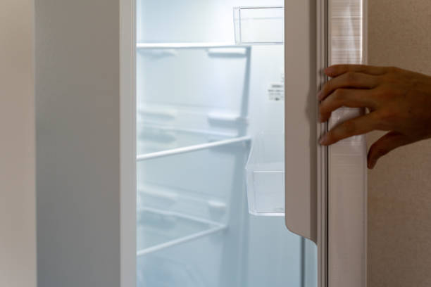 istock Opening a door of a white refrigerator by a hand. 1330117714