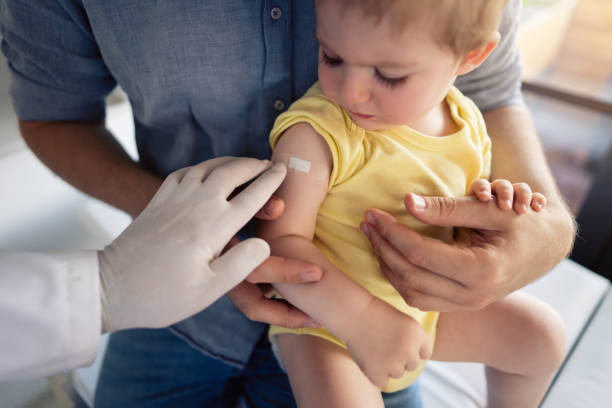 istock Unrecognizable doctor putting a patch on the little boy's shoulder after successful vaccination 1330119206