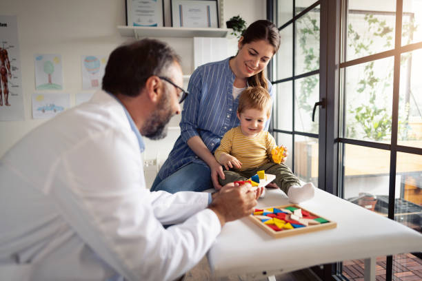 istock Male doctor playing with baby boy while he sitting on the table 1330119305