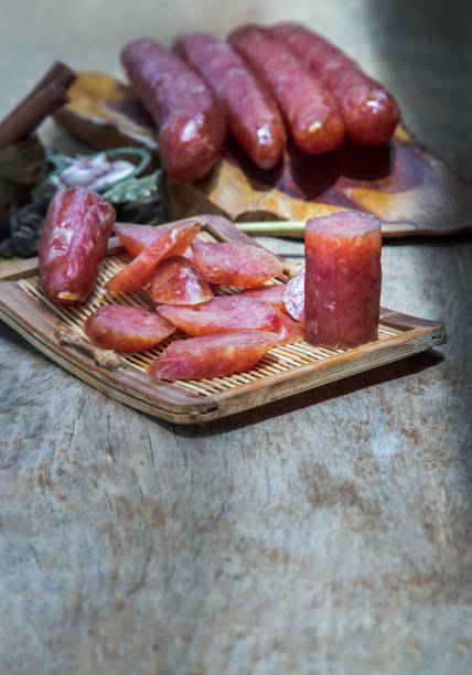 istock Dried Chinese sausage with herb on old wooden table. 1330121000