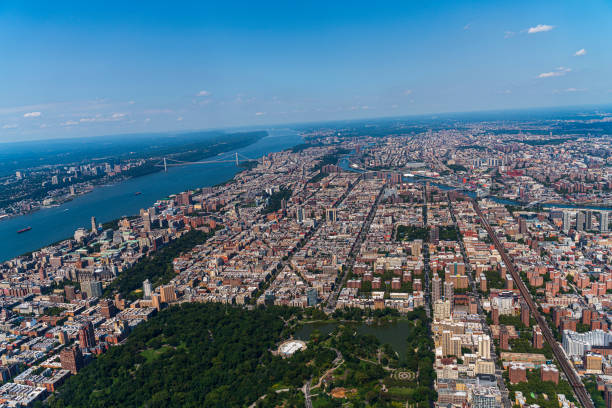 Aerial view of Central Park, Manhattan, and Harlem, and The Bronx in a distance behind, from a helicopter on a sunny summer day. Aerial view of New York City from a helicopter on a sunny summer day. harlem park stock pictures, royalty-free photos & images