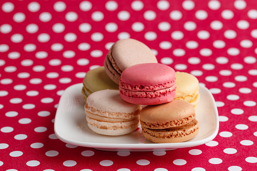 Macaroons on a red polka dotsurface.