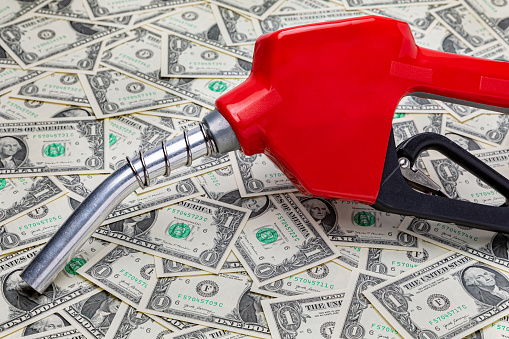 Boquilla de combustible de gasolina y dinero en efectivo. Precio del gas, impuestos, etanol y concepto de combustible fósil photo