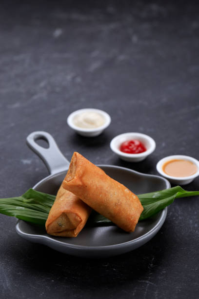 Deep Fried Spring Rolls, Popular as Lumpia or Popia. Served on Grey Pan Plate, Black marble table. Copy Space for Text Deep Fried Spring Rolls, Popularr as Lumpia or Popia. One Dish Served on Chinese New Year (Imlek) Family Dinner gorengan stock pictures, royalty-free photos & images