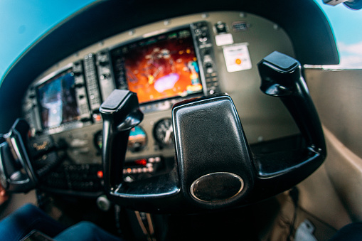 Wide Angle Fisheye Shot of the Yoke Control Wheel and Complicated Flight Instruments and Multifunction Displays in the Cockpit of a Small Single Engine Airplane