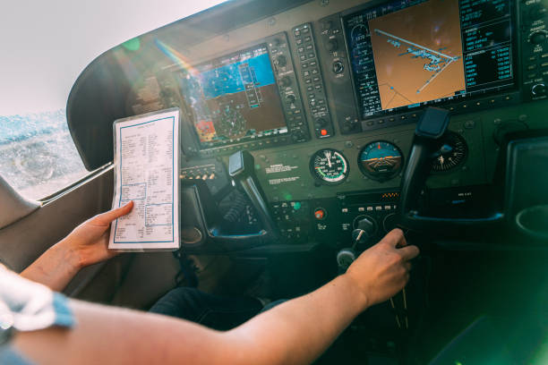 jovem adulta piloto consulta uma lista de verificação de pré-vôo enquanto ajusta o controle da mistura em um pequeno avião de motor único - vista da cabina - fotografias e filmes do acervo