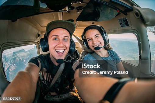 istock Two Cheerful Young Adult Friends Together in the Cockpit Flying a Small Single Engine Airplane 1330127292