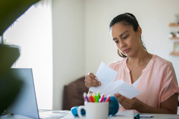 istock Woman reads bills and letters while working from home 1330128933