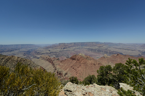 Wide angle view of Grand Canyon from the south rim on a sunny day with blue skies