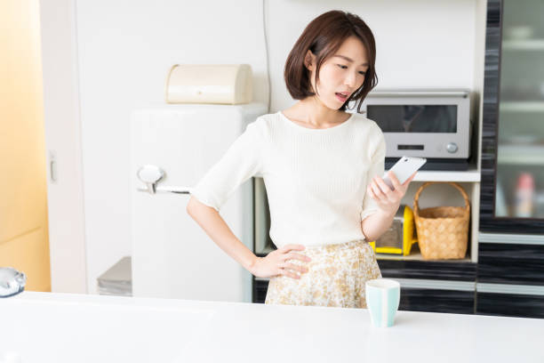 istock attractive asian woman to see a smart phone,think, 1330130663