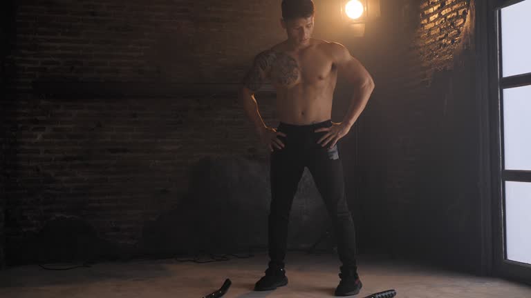 Fitness man exercising with battle rope abandoned warehouse. Tough man working out in cross training gym made inside old factory. gym, workout, fitness, training, exercise, health, fit, sport, lifestyle, healthy club,