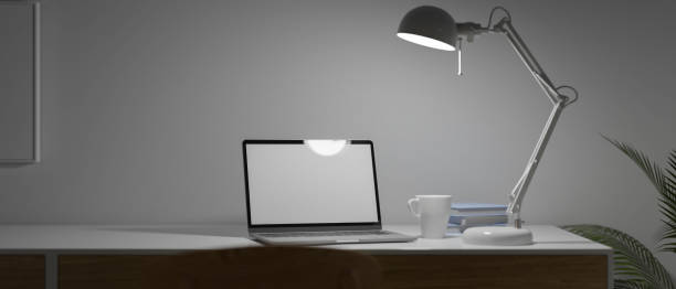 istock Modern home working space with laptop empty blank screen and modern lamp on desk at late night with slow light, Hard working, Late work, Freelance concept 1330140427