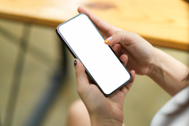 istock Close up of female hands browsing, using, paying, holding on smartphone with blank screen 1330142395