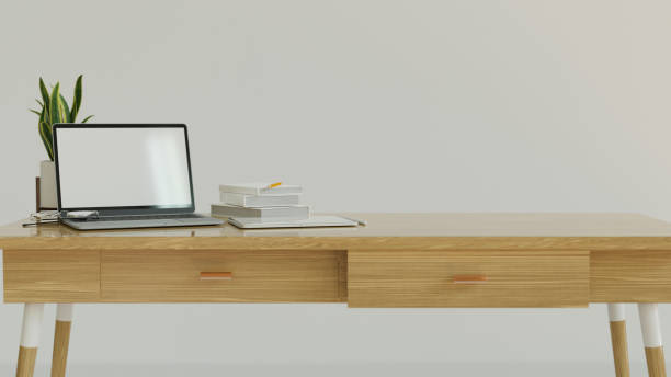 istock Comfortable work space designed with white wall, wood table and laptop mock up with blank screen and copy space 1330142601