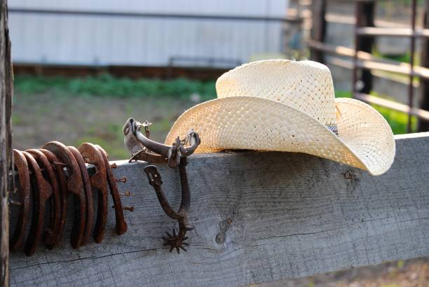 western cowboy hat na drewnianym ogrodzeniu obok butów konnych i pary ostrogów - cowboy hat wild west hat wood zdjęcia i obrazy z banku zdjęć