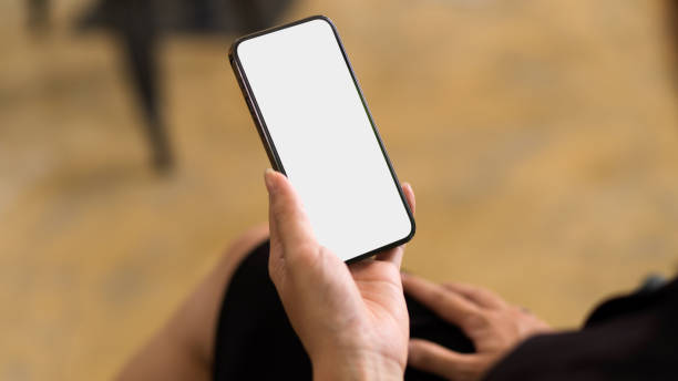 istock Smartphone with empty screen with blurred background, female reading text book on smartphone 1330145224