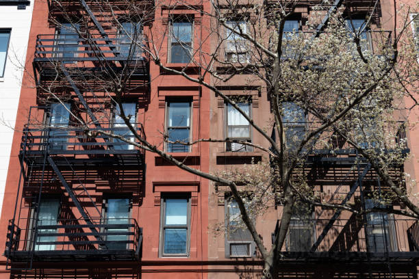 istock Colorful Old Apartment Buildings with Fire Escapes and a White Flowering Tree during Spring on the Upper East Side of New York City 1330145832
