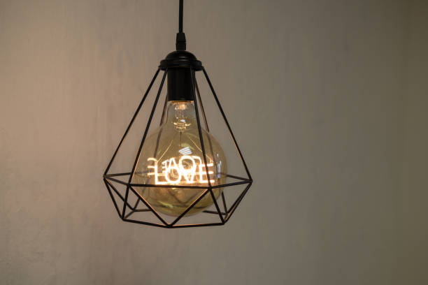 Modern loft style chandelier with a light bulb and the word love inside. stock photo