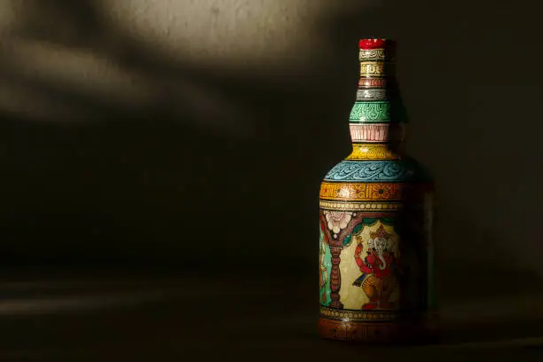 Photo of Hand-painted bottle against a dark background