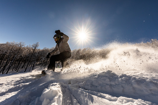 Male snowboarder having fun on a ski slope.
