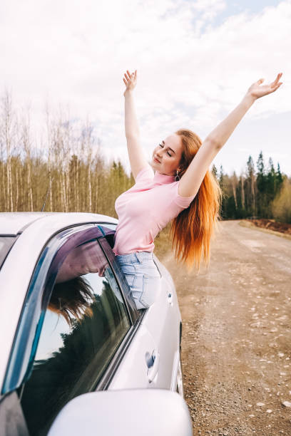 istock happy young ginger woman from window car 1330157277