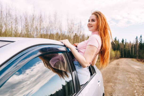 istock happy young ginger woman from window car 1330157278