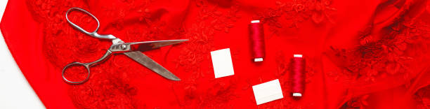 istock Fashion background. Red guipure fabric, threads and various designer accessories on a white table, top view. flat lay 1330160613