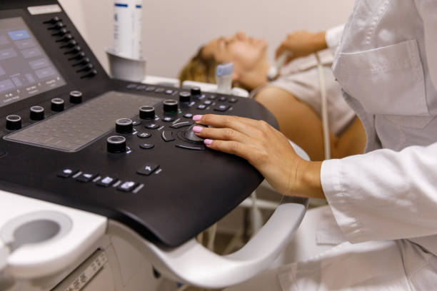 istock Female sonographer operating ultrasound machine during thyroid gland examination 1330161340