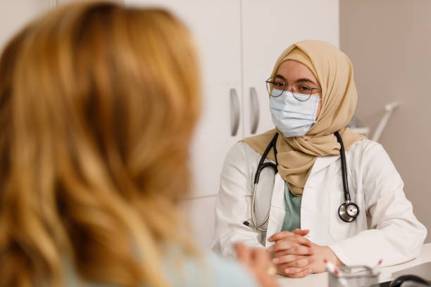 istock Muslim female doctor having a conversation with a patient 1330161440