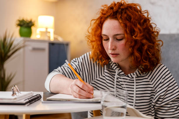 istock Young woman writing an essay for homework 1330162712