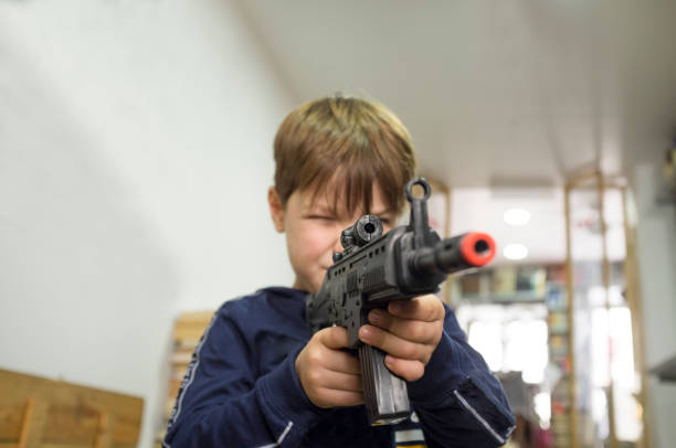istock Little boy plays with assault rifle. Toy guns concept 1330165925