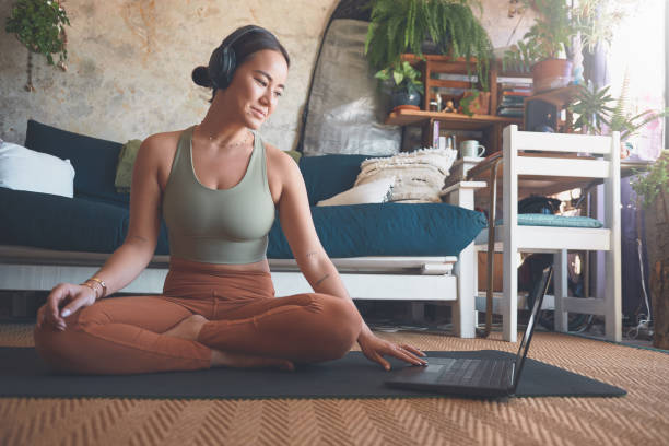 istock Shot of a young woman using a laptop while exercising at home 1330166082