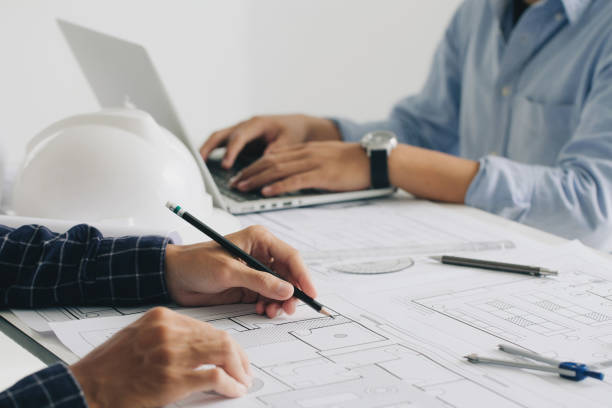 istock Engineer constuction and interior team dissussing in the office. and angineer working drawing on blueprint meeting for project working with a partner on model building plans at table in a modern office.construction concept. 1330167172