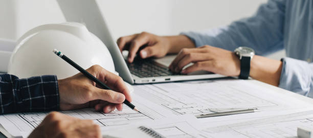 istock Engineer constuction and interior team dissussing in the office. and angineer working drawing on blueprint meeting for project working with a partner on model building plans at table in a modern office.construction concept. 1330167353