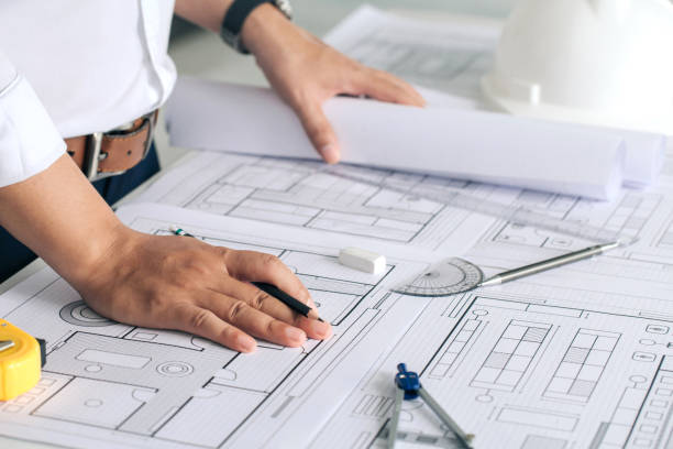 istock Close up of engineer working on blueprint architectural project at construction site at desk in office.inspection in workplace for architectural plan,sketching a construction project ,Business concept 1330168060